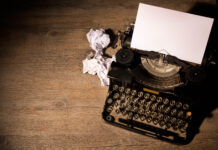 Intervenciones a través del arte: Acto y escucha Máquina de escribir, a un lado hay algunas hojas que arrugaron y apretaron en forma de bola