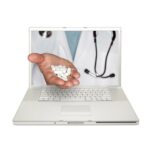 La mano de un médico sale de la pantalla de una laptop entregando un puñado de pastillas.
