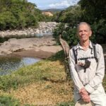 En la imagen aparece Peter Sterling, en un campo frente a un río.