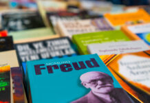 La clínica es política. Entrevista con David Pavón-Cuellar Se muestra la portada desenfocada de varios libros, sobre estos destaca uno cuyo portada de color azul muestra en grande el nombre de Freud