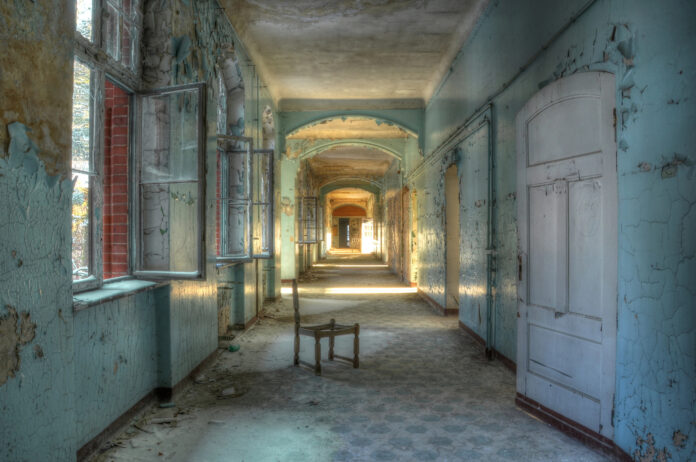 Se ve una silla en el pasillo de un hospital en estado de abandono y deterioro